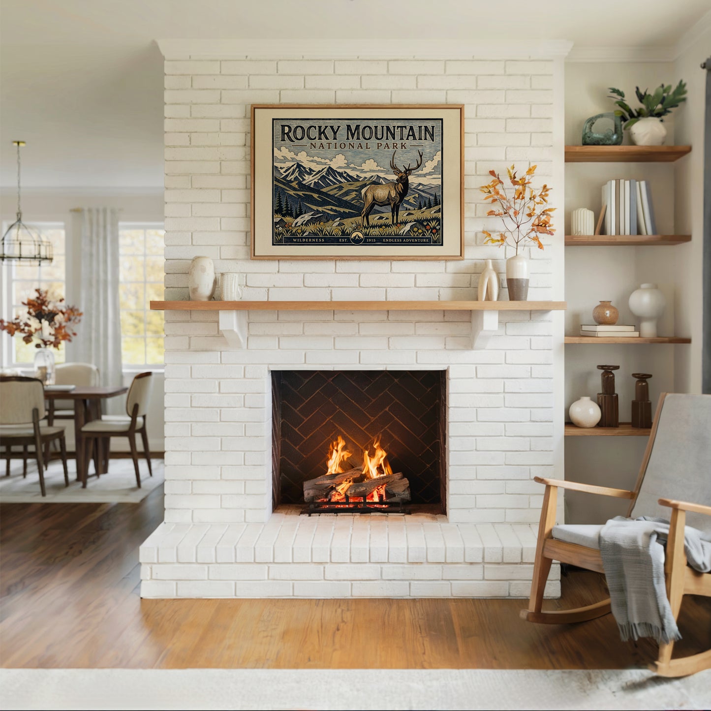 Living room with a white brick fireplace, wooden rocking chair, and framed Rocky Mountain National Park poster.