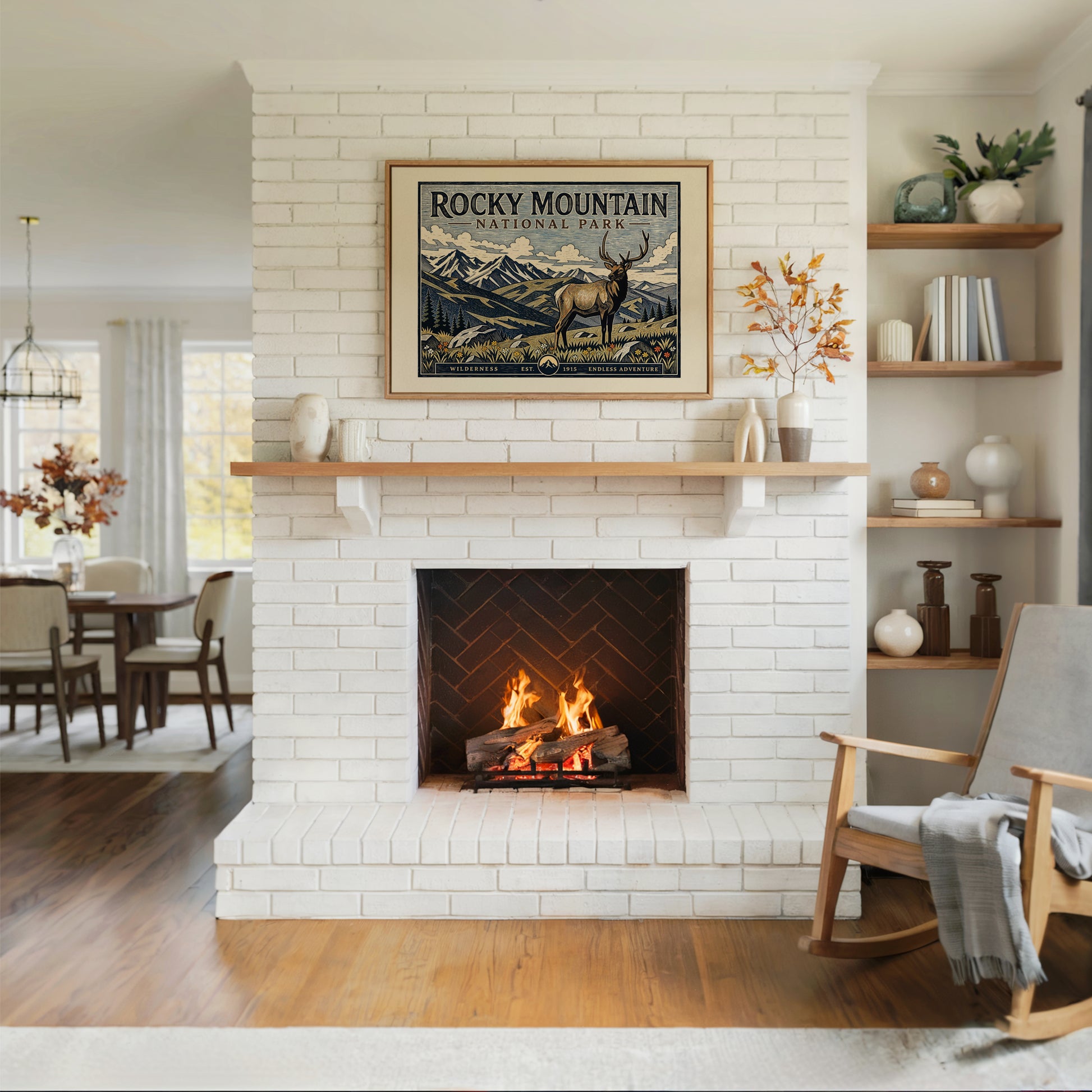 Living room with a white brick fireplace, wooden rocking chair, and framed Rocky Mountain National Park poster.